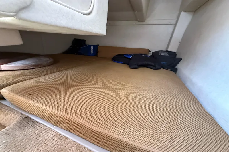 Slide: The Image of Interior cabin of 2009 Sea Ray 240 Sundancer with beige cushions and storage items. - 13