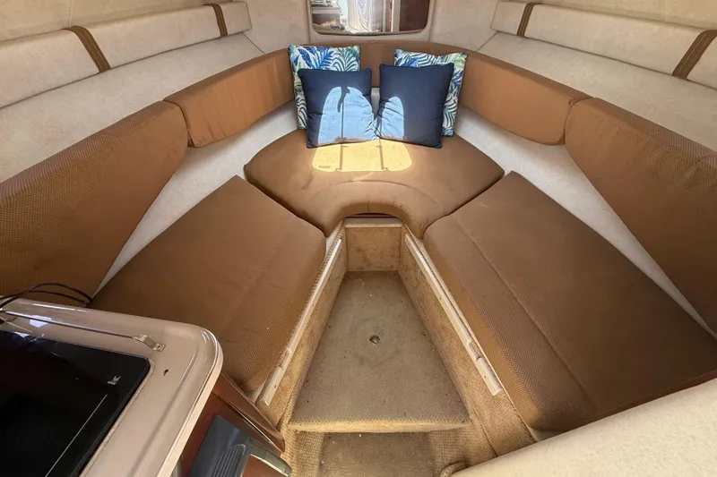 Slide: The Image of Interior of 2009 Sea Ray 240 Sundancer with brown seating and decorative pillows. - 14