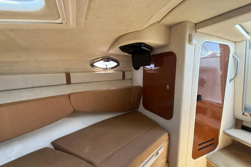 Slide: The Image of Interior cabin of 2009 Sea Ray 240 Sundancer with cozy seating and porthole window. - 15