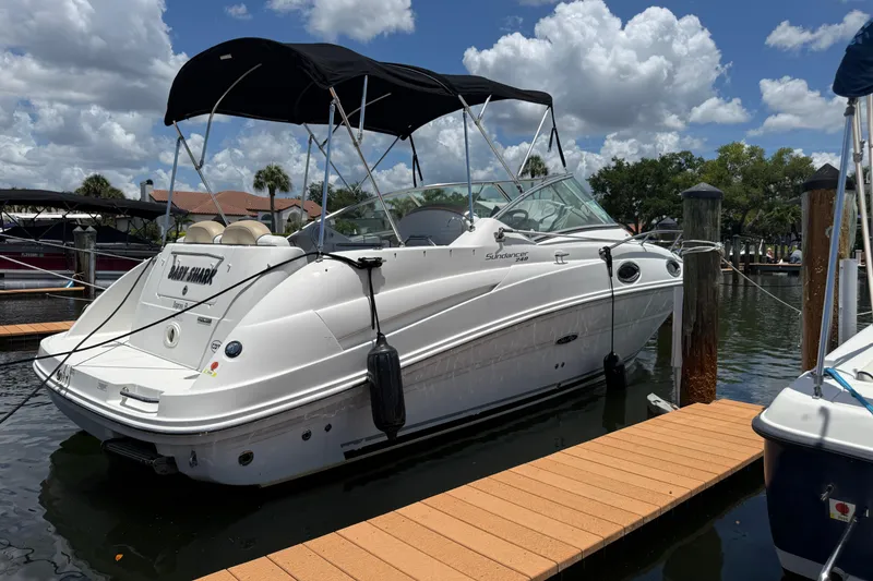 Slide: The Image of 2009 Sea Ray 240 Sundancer boat docked at marina under a cloudy sky. - 3