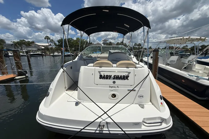 Slide: The Image of 2009 Sea Ray 240 Sundancer docked, featuring "Baby Shark" name, under a cloudy sky. - 4