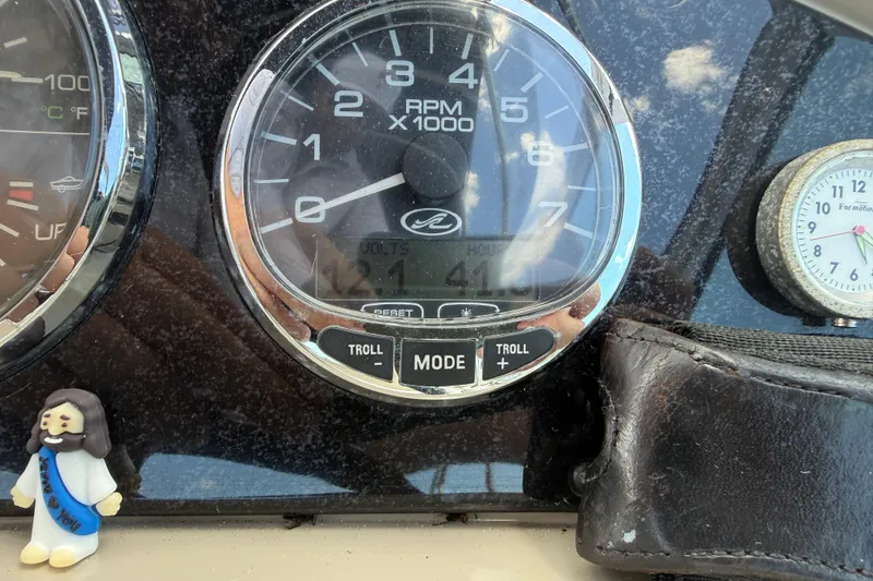 Slide: The Image of Dashboard of a 2009 Sea Ray 240 Sundancer boat with RPM gauge and small figurine. - 6