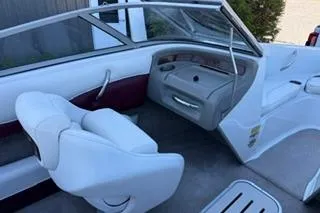 Slide: The Image of 2006 Crownline 180 BR boat interior with white and maroon seating, steering console, and open windshield. - 11
