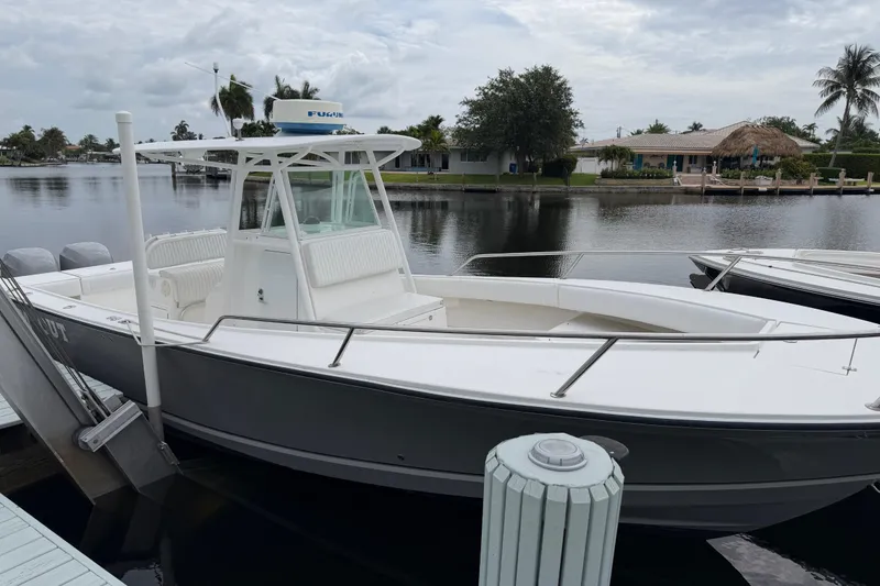 Slide: The Image of 2002 Regulator 32 Forward Seating boat docked by a serene waterfront. - 1