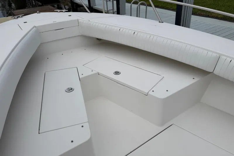 Slide: The Image of 2002 Regulator 32 Forward Seating boat with white cushioned seating and storage compartments. - 15