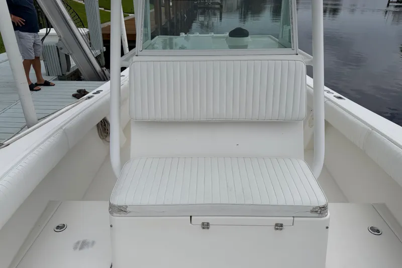 Slide: The Image of 2002 Regulator 32 Forward Seating boat with white cushioned seats at the dock. - 16