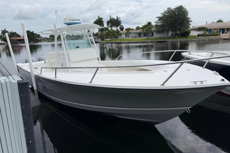 Slide: The Image of 2002 Regulator 32 Forward Seating boat docked on a calm waterfront. - 2