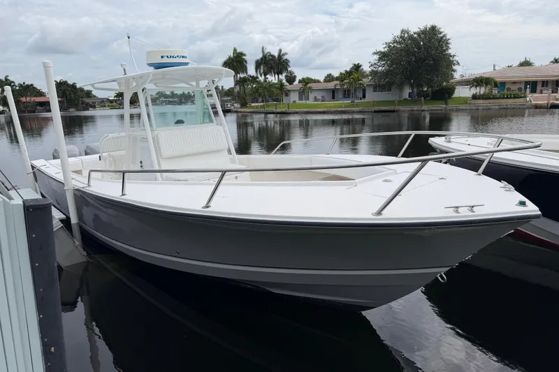 Slide: The Image of 2002 Regulator 32 Forward Seating boat docked on calm water. - 3