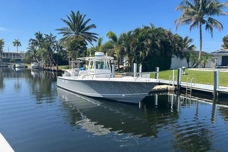 Slide: The Image of 2002 Regulator 32 Forward Seating boat docked in a scenic canal with palm trees. - 34
