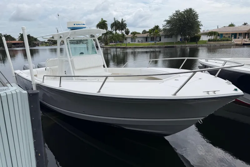 Slide: The Image of 2002 Regulator 32 Forward Seating boat docked on a calm waterfront. - 4