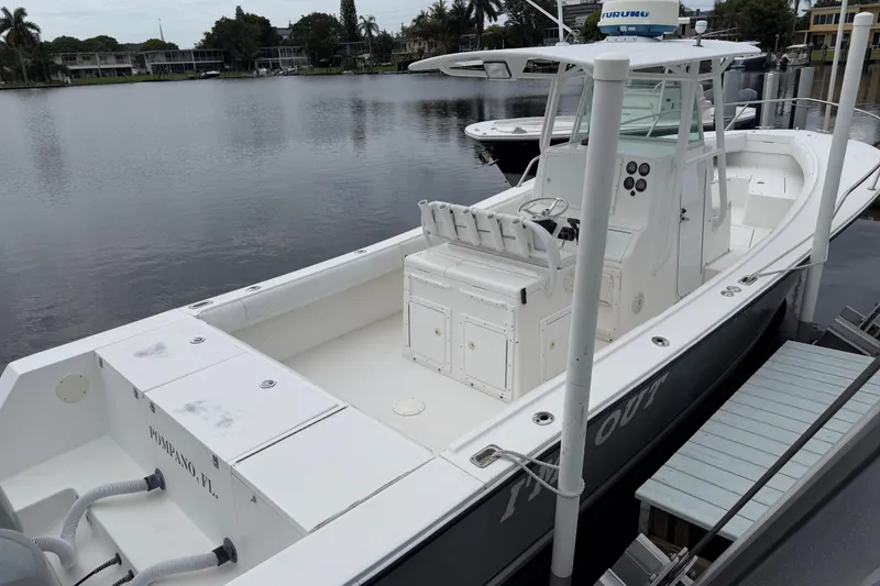 Slide: The Image of 2002 Regulator 32 Forward Seating boat docked by a calm waterfront. - 6