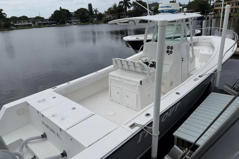 Slide: The Image of 2002 Regulator 32 Forward Seating boat docked by a calm waterfront. - 7