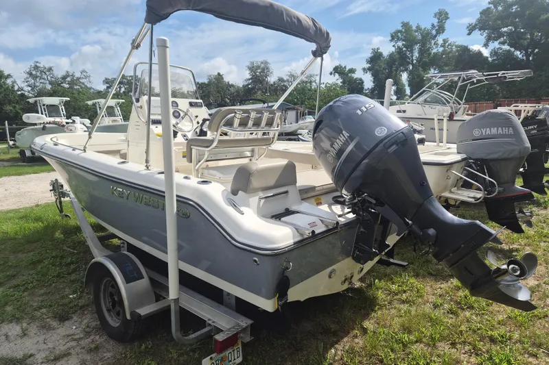 Slide: The Image of 2022 Key West 189 FS boat with Yamaha engine on a trailer, parked outdoors. - 2