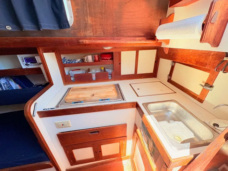 Slide: The Image of Interior of 1972 Tartan 34 Classic yacht, featuring kitchen and wood paneling. - 15