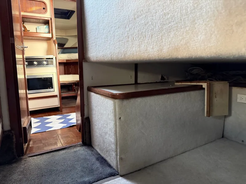 Slide: The Image of Interior of 1989 Carver 320 Voyager yacht, featuring kitchen and sleeping area. - 9