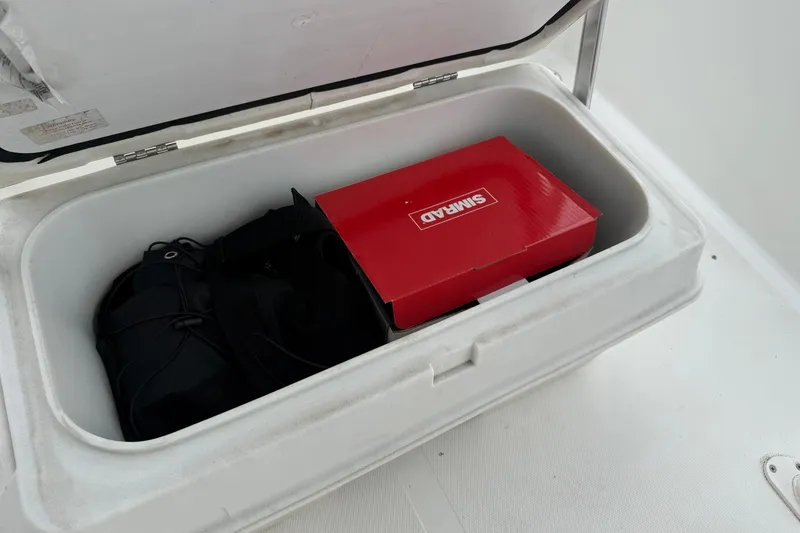 Slide: The Image of Open storage compartment on 2005 Sea Pro 190 Center Console with gear and red Shimano box. - 14