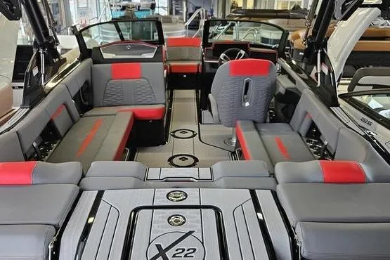 Slide: The Image of 2025 MasterCraft X22 boat interior with gray and red seating, modern design. - 11