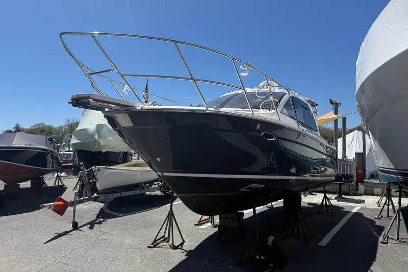 Slide: The Image of 2022 Cutwater C-24 Coupe boat on stands in a marina under clear blue sky. - 12