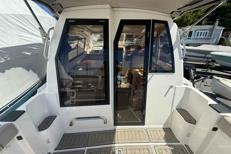Slide: The Image of 2022 Cutwater C-24 Coupe boat cockpit with glass doors and seating area. - 15