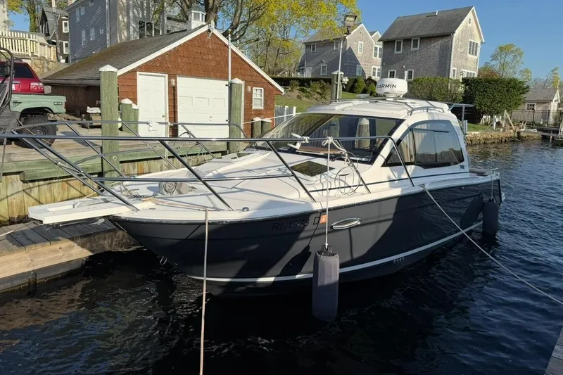 Slide: The Image of 2022 Cutwater C-24 Coupe docked, surrounded by houses. - 2