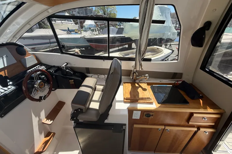 Slide: The Image of Interior of 2022 Cutwater C-24 Coupe boat with helm and kitchenette. - 23