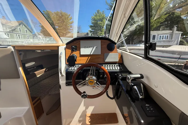 Slide: The Image of Interior view of 2022 Cutwater C-24 Coupe boat cockpit with steering wheel and controls. - 24