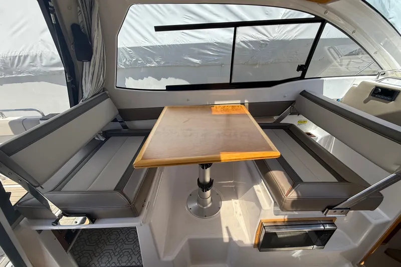 Slide: The Image of Interior of 2022 Cutwater C-24 Coupe with seating and wooden table. - 25