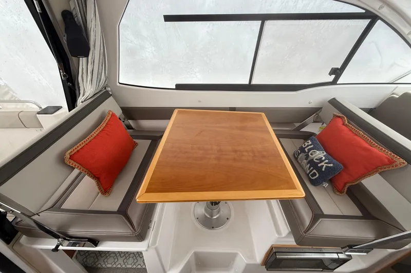 Slide: The Image of 2022 Cutwater C-24 Coupe interior with dining table and cushioned seating. - 26
