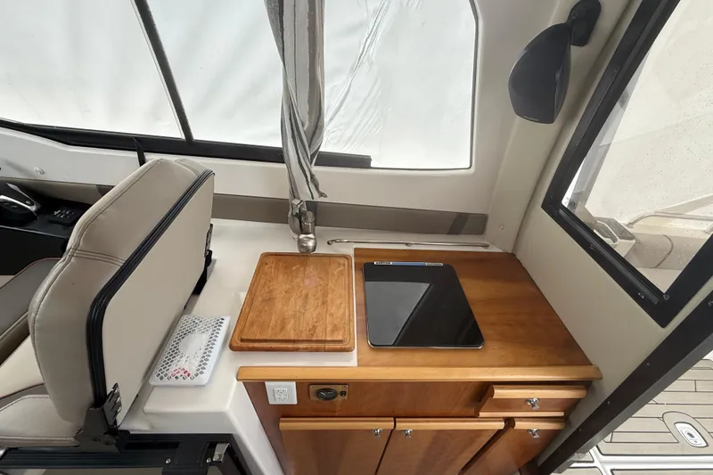 Slide: The Image of Interior of 2022 Cutwater C-24 Coupe featuring a compact kitchen area with wooden cabinetry. - 29