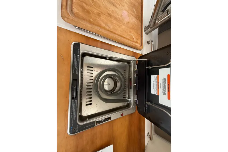 Slide: The Image of Stove inside 2022 Cutwater C-24 Coupe boat, featuring a compact design and wooden countertop. - 30