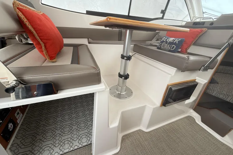 Slide: The Image of Interior of 2022 Cutwater C-24 Coupe with seating and table, featuring decorative pillows. - 34
