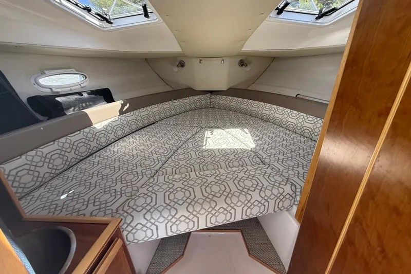 Slide: The Image of Interior cabin of 2022 Cutwater C-24 Coupe with patterned bedding and wood accents. - 37