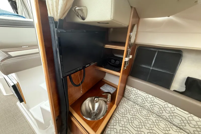 Slide: The Image of 2022 Cutwater C-24 Coupe interior with TV, sink, and patterned seating. - 49