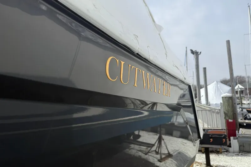 Slide: The Image of 2022 Cutwater C-24 Coupe boat docked, showcasing sleek design and branding. - 56