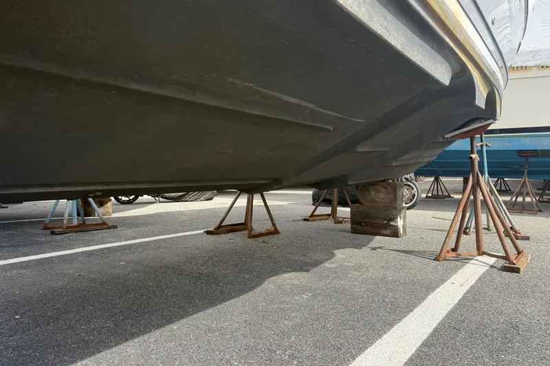 Slide: The Image of 2022 Cutwater C-24 Coupe boat hull on stands in a parking lot. - 58