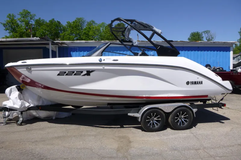 The Image of 2026 Yamaha Boats 222XD on trailer, white with red accents, parked outdoors. - 1