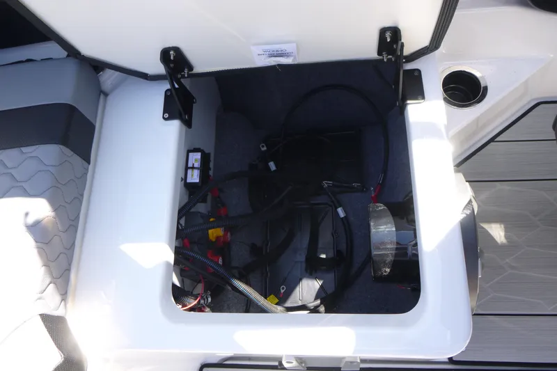 Slide: The Image of Open storage compartment in 2026 Yamaha Boats 222XD, showing wiring and components. - 16