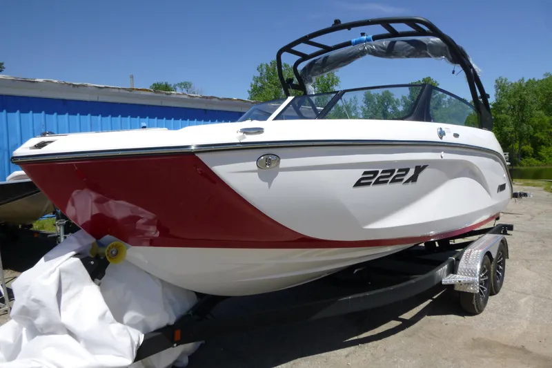 Slide: The Image of 2026 Yamaha Boats 222XD, red and white, on trailer, outdoors. - 2