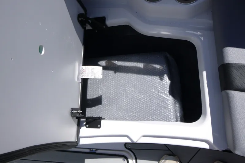 Slide: The Image of Open storage compartment in 2026 Yamaha Boats 222XD, featuring bubble-wrapped contents. - 7