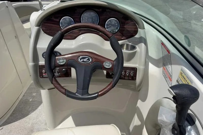 Slide: The Image of Steering console of a 2005 Sea Ray 220 Sundeck boat with gauges and controls. - 12