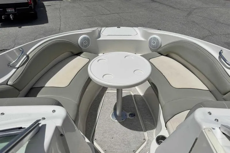 Slide: The Image of 2005 Sea Ray 220 Sundeck boat interior with circular table and cushioned seating. - 16