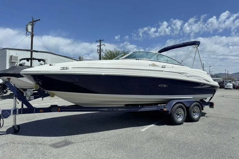 Slide: The Image of 2005 Sea Ray 220 Sundeck boat on trailer under clear blue sky. - 2