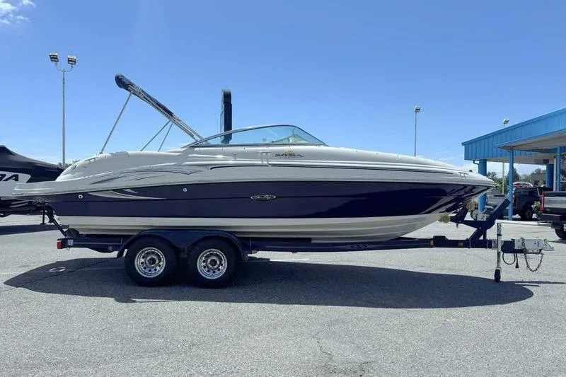 Slide: The Image of 2005 Sea Ray 220 Sundeck boat on trailer under clear blue sky. - 5