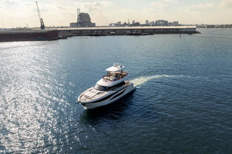 Slide: The Image of Luxury yacht Prestige F4.9 cruising in a sunlit harbor, 2025 model. - 1