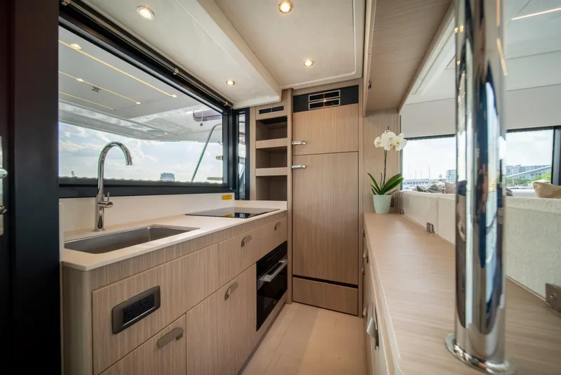 Slide: The Image of Modern kitchen interior on a 2025 Prestige F4.9 yacht, featuring sleek cabinetry and stainless steel fixtures. - 18