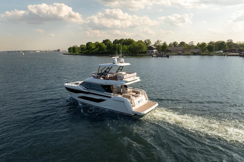 Slide: The Image of Luxury Prestige F4.9 yacht cruising on a serene lake, 2025 model. - 2