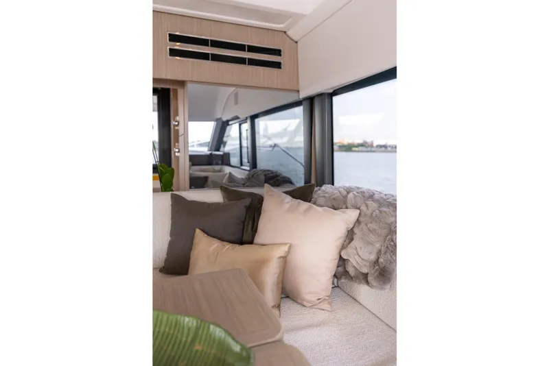 Slide: The Image of Luxurious interior of 2025 Prestige F4.9 yacht with plush cushions and scenic window view. - 24