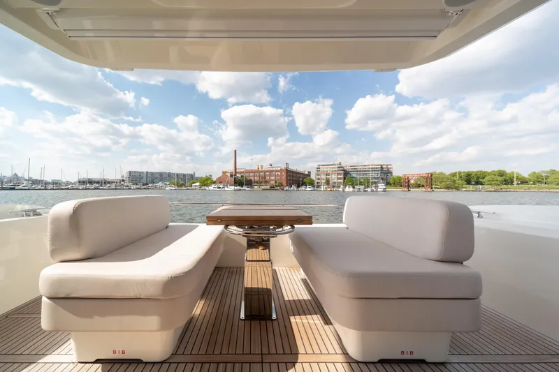 Slide: The Image of Luxurious Prestige F4.9 yacht deck with elegant seating, overlooking a scenic waterfront view. - 43
