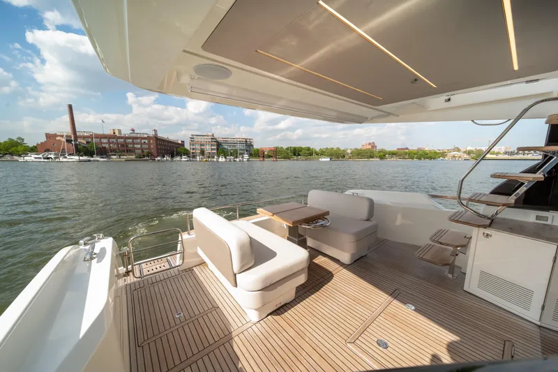 Slide: The Image of Luxurious 2025 Prestige F4.9 yacht deck with seating, overlooking a scenic waterfront. - 44