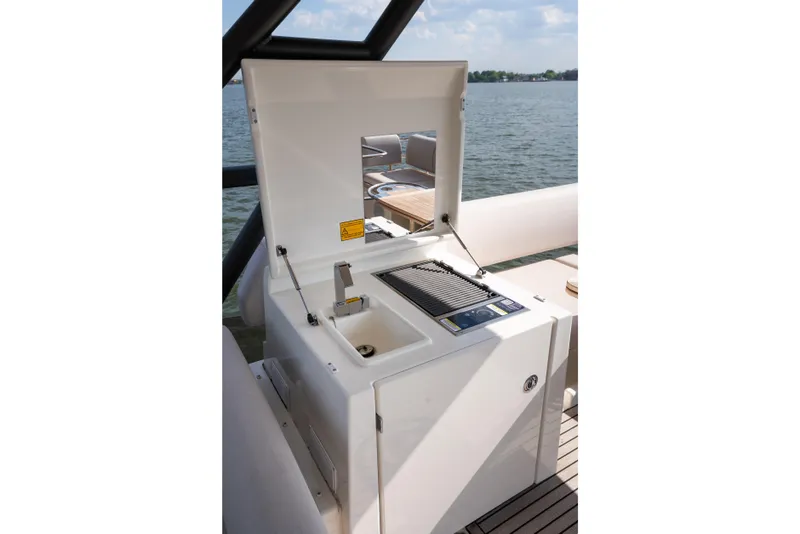 Slide: The Image of Outdoor kitchen on a 2025 Prestige F4.9 yacht with grill and sink by the water. - 56